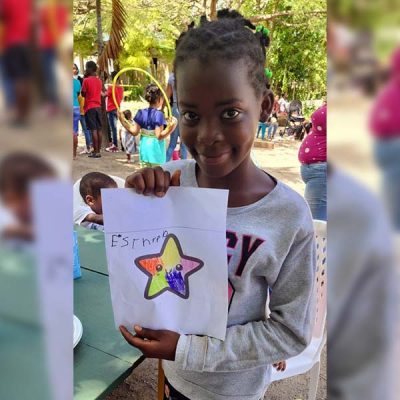 Artista mostrando su dibujo de estrella para bolso solidario